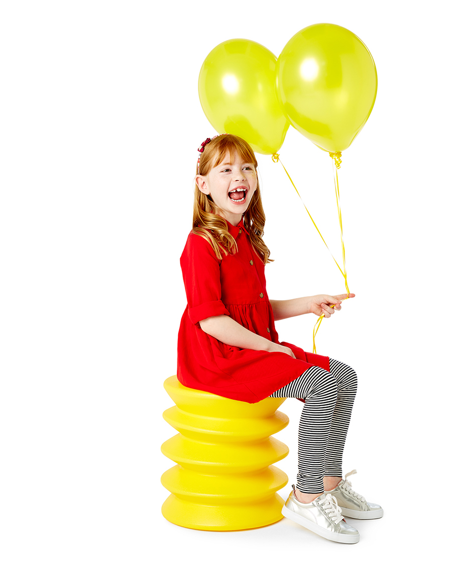 Bold and colorful girl holding balloons, shot on a white seamless background.
