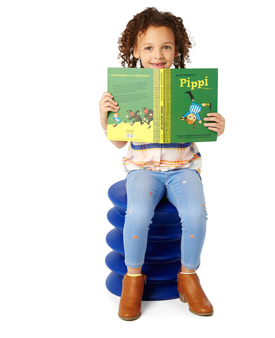 Multi-racial girl reading a colorful book, shot on a white seamless background.